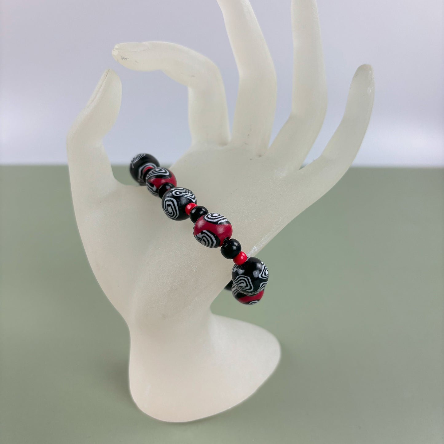 Mystic Swirl – Handgefertigtes Perlenarmband in Schwarz-Rot mit einzigartigem Spiralmuster