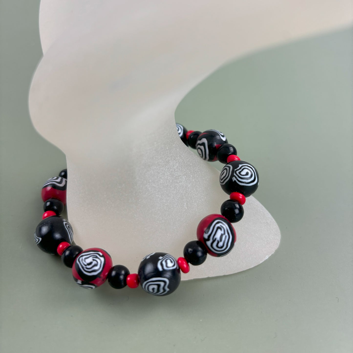 Mystic Swirl – Handgefertigtes Perlenarmband in Schwarz-Rot mit einzigartigem Spiralmuster