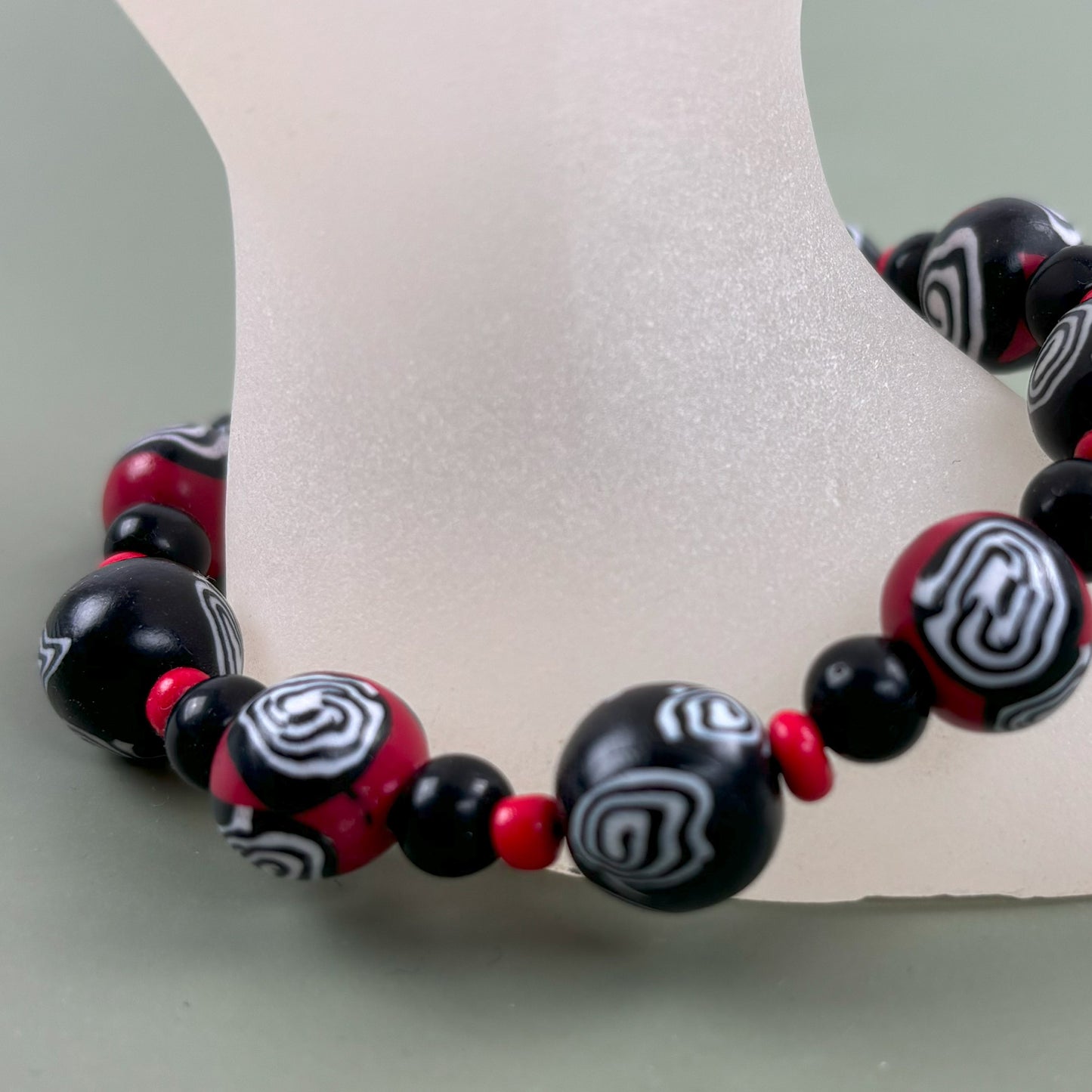 Mystic Swirl – Handgefertigtes Perlenarmband in Schwarz-Rot mit einzigartigem Spiralmuster