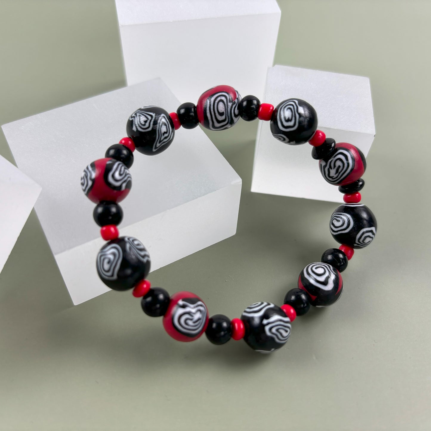 Mystic Swirl – Handgefertigtes Perlenarmband in Schwarz-Rot mit einzigartigem Spiralmuster