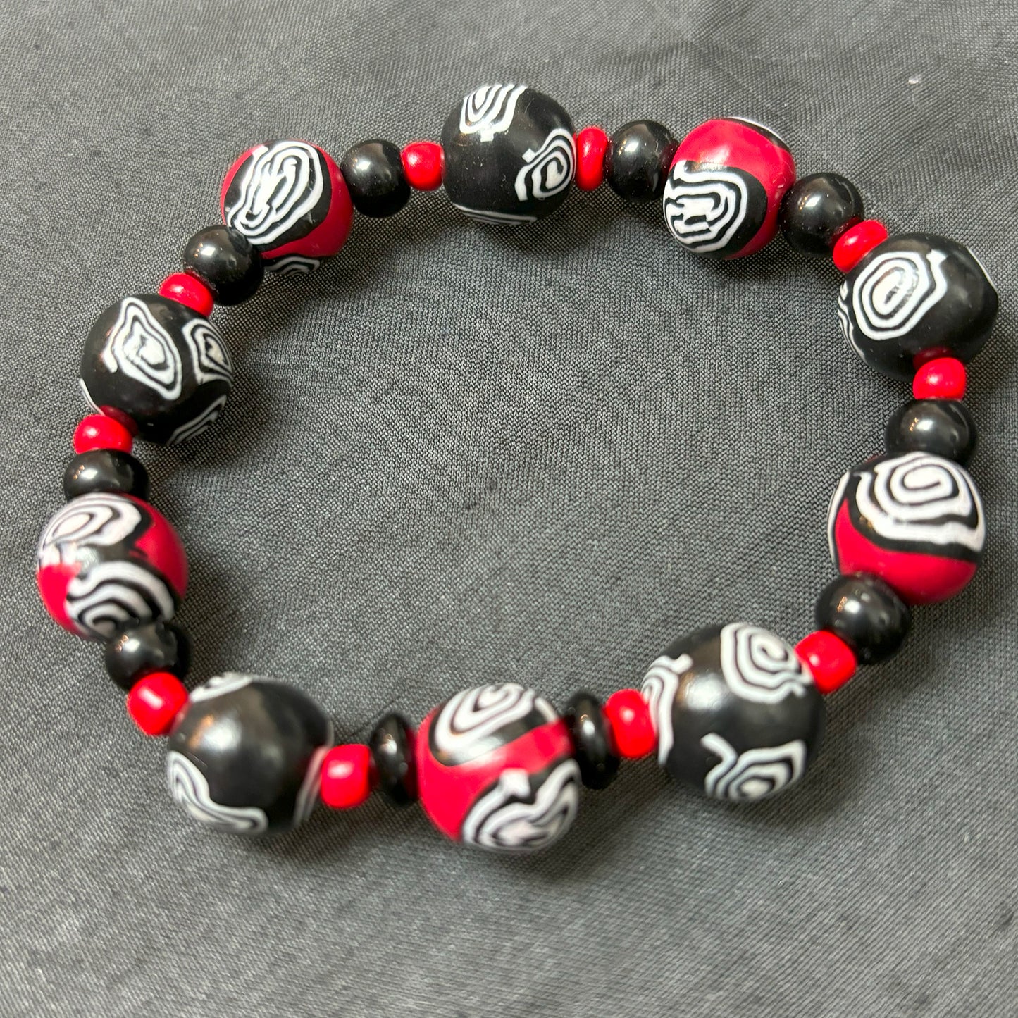Mystic Swirl – Handgefertigtes Perlenarmband in Schwarz-Rot mit einzigartigem Spiralmuster