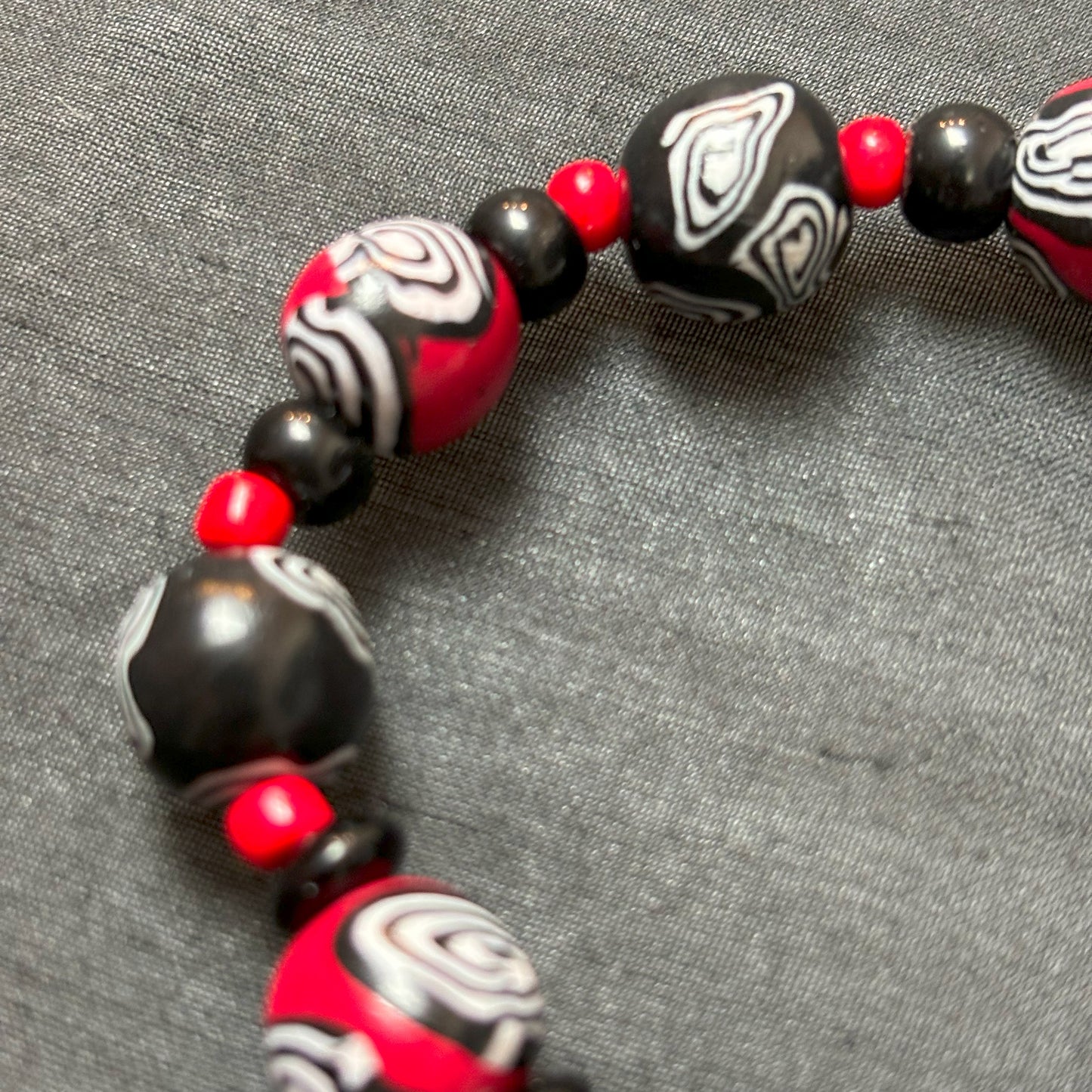 Mystic Swirl – Handgefertigtes Perlenarmband in Schwarz-Rot mit einzigartigem Spiralmuster