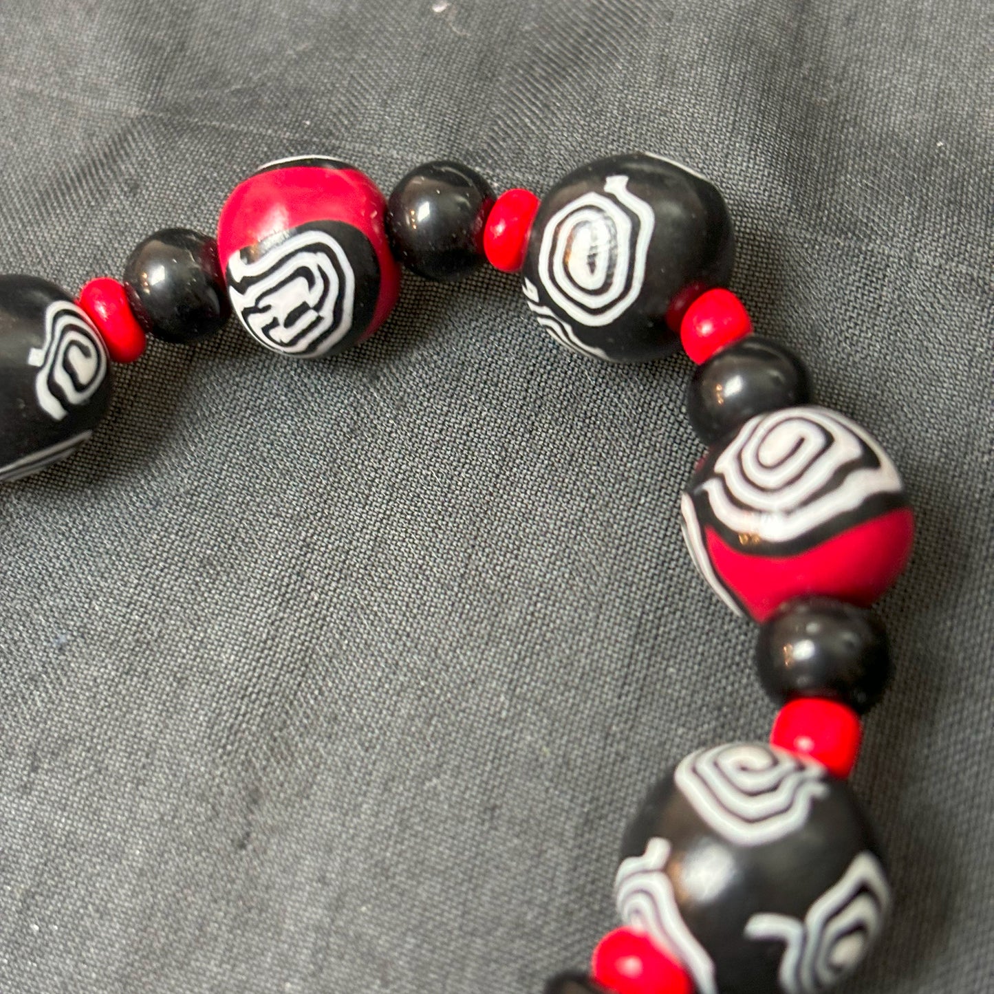 Mystic Swirl – Handgefertigtes Perlenarmband in Schwarz-Rot mit einzigartigem Spiralmuster